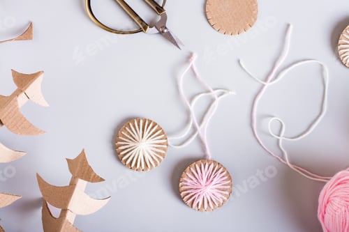 Preview: DIY Christmas handmade decorations made of cardboard and yarn on the table. Top view. Closeup