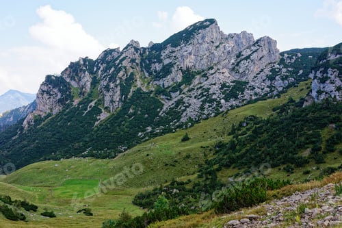 Preview: Mountain landscape with rocky peaks and green valleys.