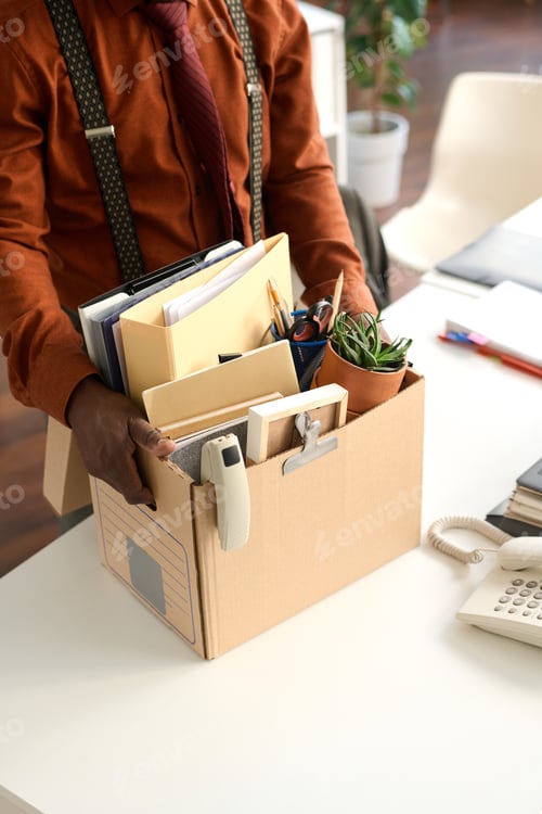 Preview: Man Holding Box at Workplace Table Close Up