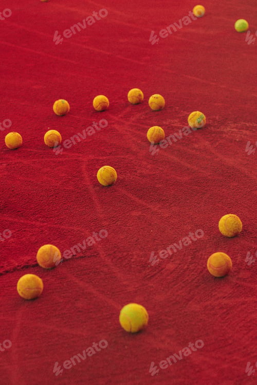 Preview: Vertical shot of tennis balls on a red court outdoors - great for aesthetic wallpapers