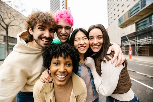 Preview: Happy diverse friends hugging and smiling outdoors
