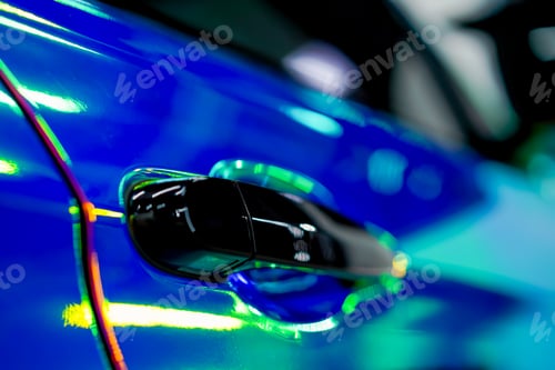 Preview: Close-up of the door handle of a luxury car covered with chamelion film at detailing