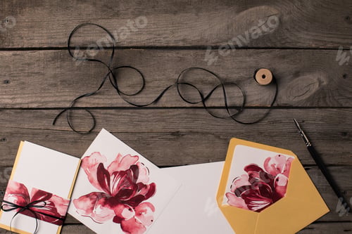 Preview: composition of holiday invitations with floral illustrations and thread on rustic wooden table