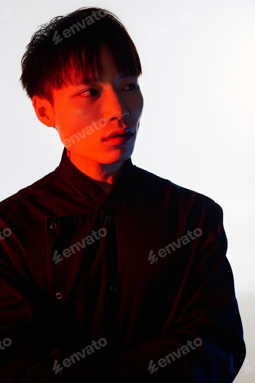 Preview: Stylish young man in a striking pose showcasing modern fashion and artistic lighting