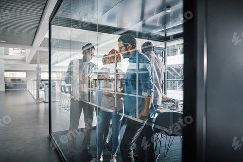 Preview: Businesspeople brainstorming together on the glass wall of a boardroom