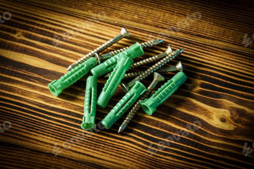 Preview: Closeup shot of a row of screws laid on a wooden table