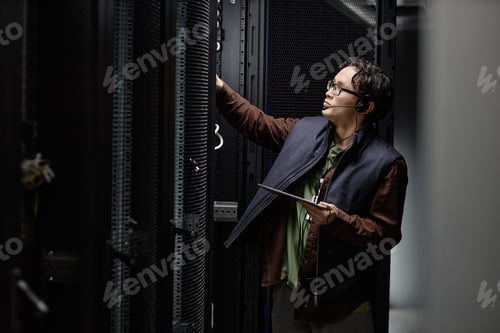 Preview: Young Adult Asian Man Inspecting Server Rack While Holding Digital Tablet