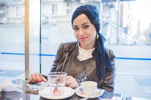 Preview: Woman Relaxing with Coffee in Urban Cafe