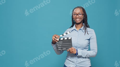 Preview: Portrait of african american woman holding film slate board