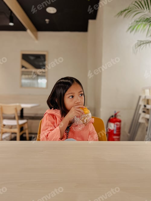 Preview: A young kid eating at the cafeteria while waiting doctors appointments