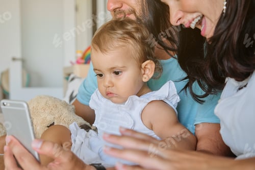 Preview: Crop parents with girl using smartphone