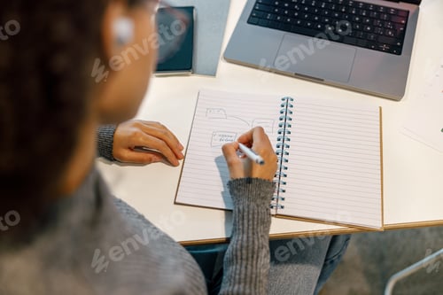Preview: Close up of Woman freelancer working laptop and making notes while sitting in cafe