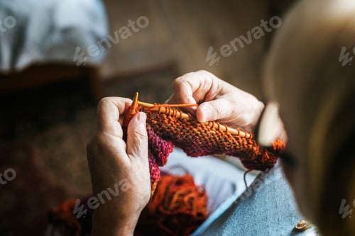 Preview: Senior woman knitting for hobby at home