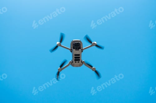 Preview: Consumer drone with camera hovering against blue sky