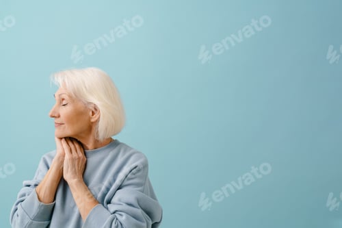 Preview: Beautiful senior woman with closed eyes and folded hands