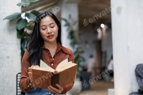 Preview: Young woman reading a book in a bookstore coffee shop