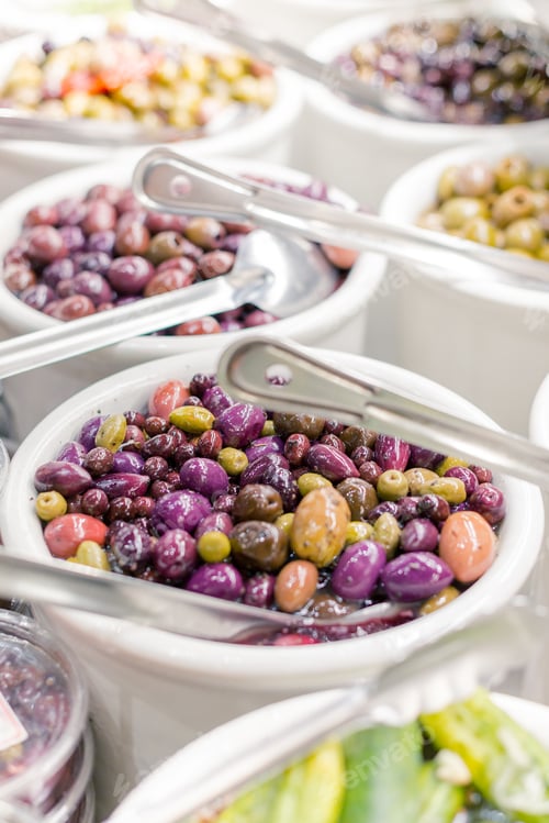 Preview: Closeup of colorful olives stored in a white pack at the store