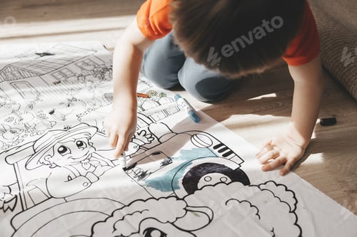 Preview: Cute little boy drawing with felt pens on floor at home. Early education concept.