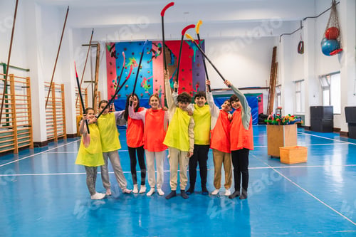 Preview: Students holding hockey sticks during physical education class in school gym