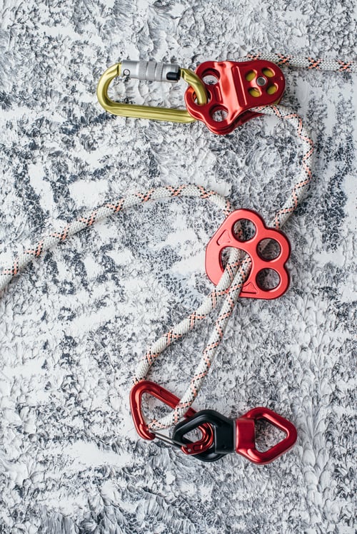 Preview: Isolated photo of climbing equipment. Part of carabiner lying on the white and grey colored table
