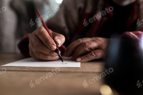 Preview: A man with dirty hands writing on a sheet of paper