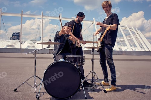 Preview: rock band in black clothing playing music on street