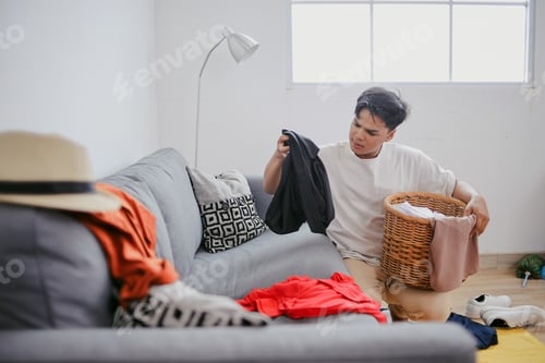 Preview: Young Man Tidy Up Messy Clothes, Put In Laundry Basket