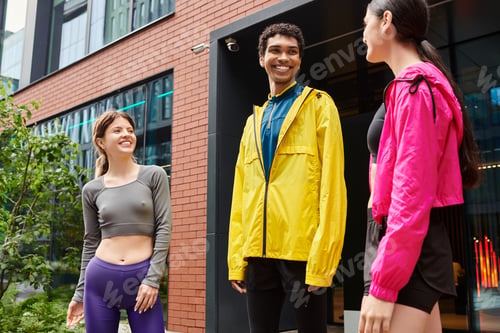 Preview: Sporty young individuals enjoying a lively conversation in an urban setting during the afternoon