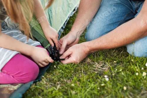 Preview: Can I help, daddy. Cropped shot of a little girl helping her father to put up a tent.