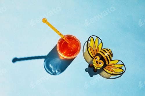 Preview: Jar with honey and shadow on a blue background, candy cane bee with shadow.