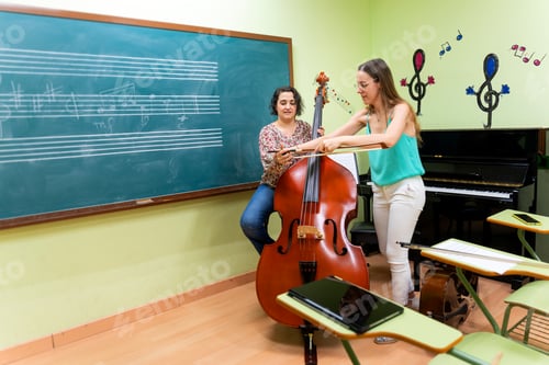 Visualização: Professor de música ajudando aluno tocando contrabaixo na sala de aula