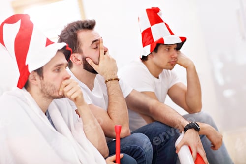 Preview: Happy male friends cheering and watching sports on tv