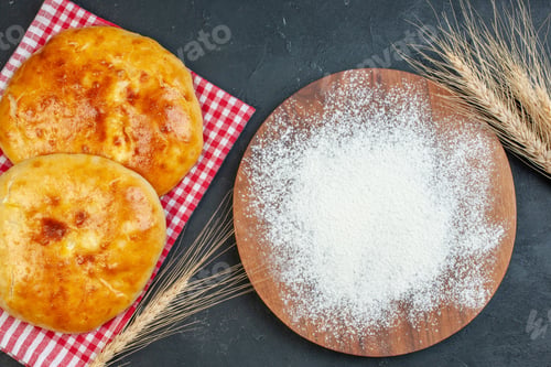 Preview: Top view of delicous fresh baked pastries on red stripped towel and flour on the wooden cutting