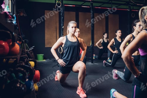 Preview: Group of women training in gym, stretching with hands on hips