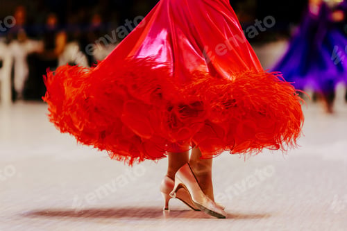 Preview: close-up red ball gown and feet in slipper of female dancer on parquet