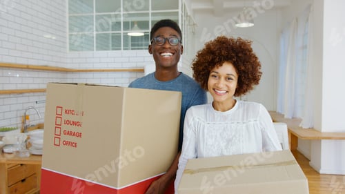 Preview: Portrait Of Smiling Young Couple Carrying Packing Boxes Moving Into New Home