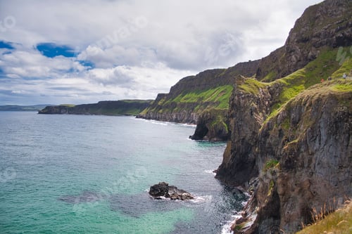 Preview: Beautiful view of a cliff and calm sea under the blue cloudy sky