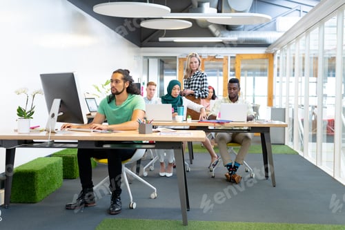 Preview: Front view of diverse business people working at desk in a modern office
