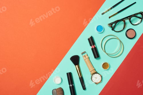 Preview: Mascara, watch, lipstick, bracelets, eyeshadow, blush, glasses and cosmetic brushes on turquoise
