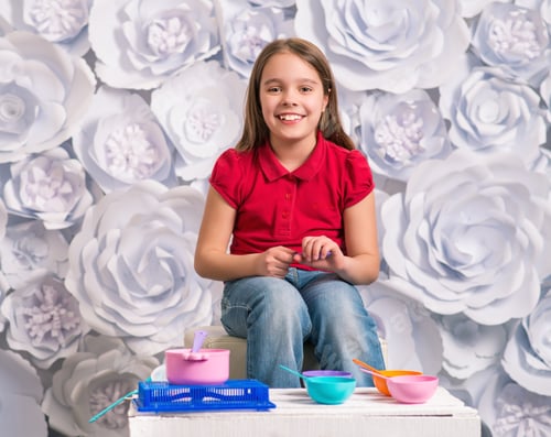 Preview: Happy little girl sits in front of children's toys