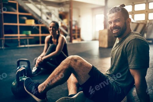Preview: Smiling young people sitting in a gym after working out