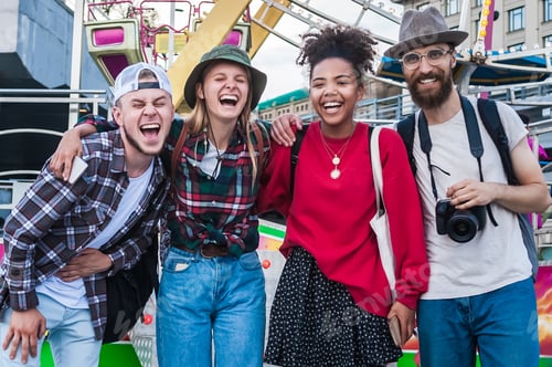 Preview: happy young multiethnic friends standing together and laughing in amusement park
