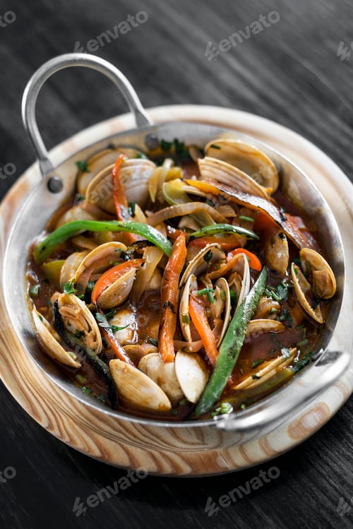 Preview: mediterranean clam and vegetable stew in pot at barcelona restaurant