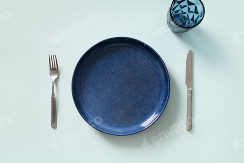 Preview: Empty blue plate on blue kitchen background.