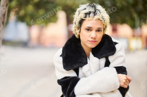 Preview: Stylish woman wearing faux fur coat looking at camera
