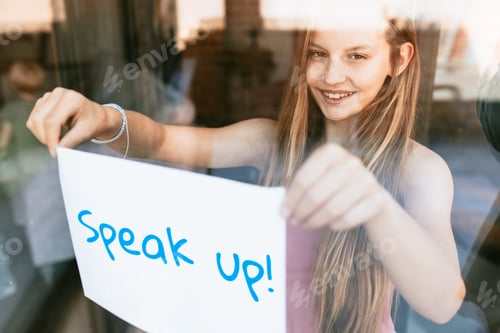Preview: Speak up! paper, young girl showing sign through glass window
