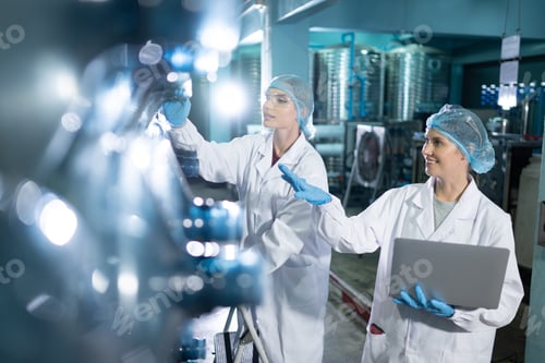 Preview: Portrait of a scientist in the drinking water factory using a ladder, looking at the water tanks