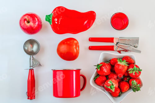 Preview: Overhead flat lay of bright red kitchen objects on a white background