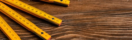 Preview: top view of folding ruler on wooden table, labor day concept, banner