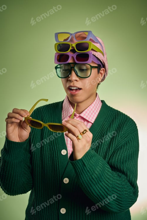 Preview: Stylish man in a vibrant green studio flaunts trendy sunglasses